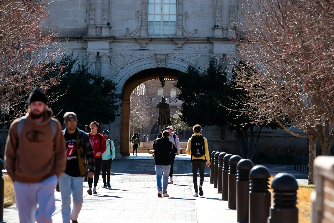 Students walking through a university campus archway