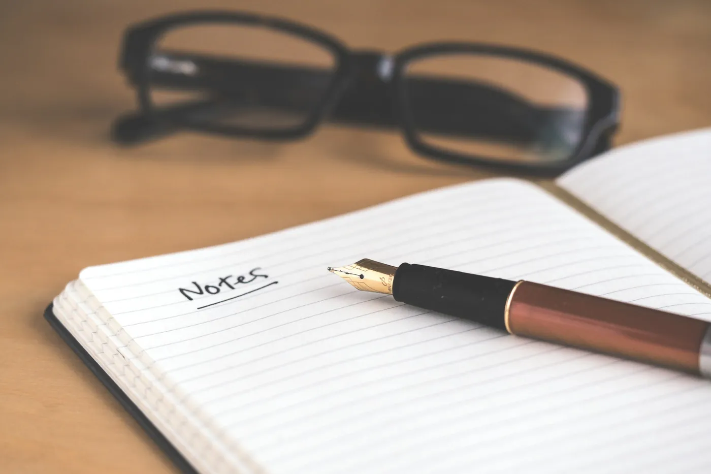 A fountain pen resting on an open notebook